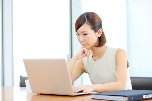 girl-with-short-hair-at-table-looking-at-laptop-with-pensive-expression